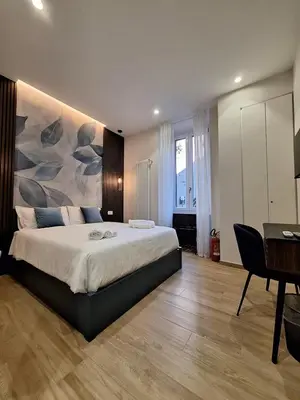 a bedroom with a large bed with a painting on the wall at Deltis Boutique Apartments in Rome