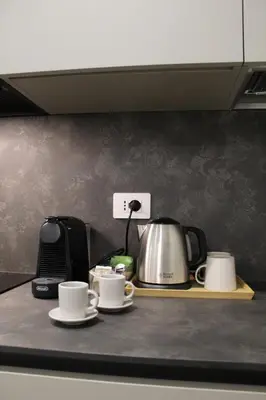 a counter with two coffee cups and a tea kettle at Deltis Boutique Apartments in Rome