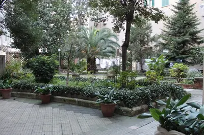 a garden with plants and trees in a city at Deltis Boutique Apartments in Rome