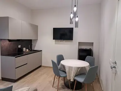 a kitchen with a table and chairs in a room at Deltis Boutique Apartments in Rome