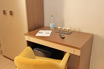 a desk with a bottle of water and a yellow chair at Roma Suite Centro in Rome