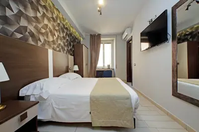 a hotel room with a white bed and a television at Roma Suite Centro in Rome