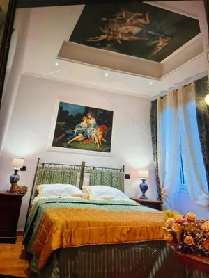 a bedroom with a bed with a painting on the wall at Sancta Scala in Rome