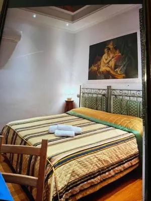 a bedroom with two beds and a painting on the wall at Sancta Scala in Rome