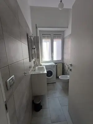 a bathroom with a sink and a washing machine at Alessia C Locazione turistica in Rome