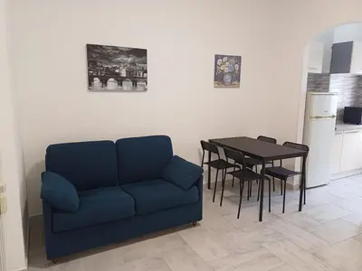 a living room with a blue couch and a table at Alessia C Locazione turistica in Rome