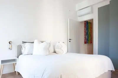 a white bedroom with a white bed with white pillows at Casa Monteverde near Trastevere and the city center in Rome