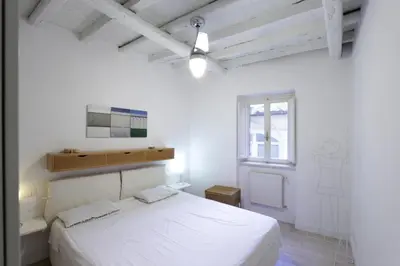a white bedroom with a large bed and a window at Grotte Apartment in Rome