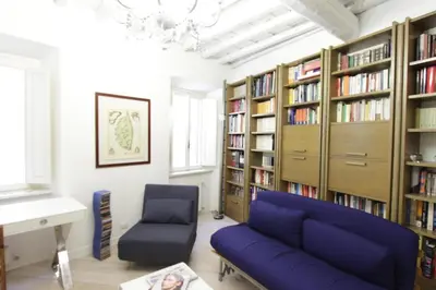 a living room with a blue couch and bookshelves at Grotte Apartment in Rome