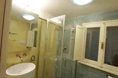 a bathroom with a glass shower and a sink at Grotte Apartment in Rome