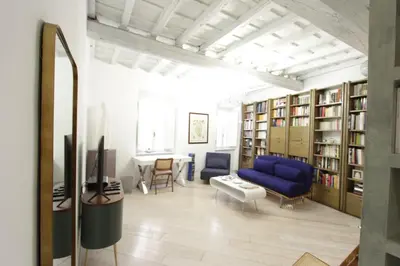 a living room with a blue couch and book shelves at Grotte Apartment in Rome