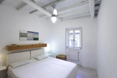 a white bedroom with a bed and a window at Grotte Apartment in Rome