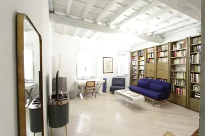 a living room with a blue couch and book shelves at Grotte Apartment in Rome
