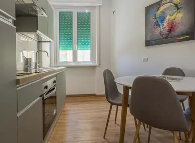 a kitchen with a table and chairs in a room at JHHIT - Panoramic Modern Penthouse in Rome