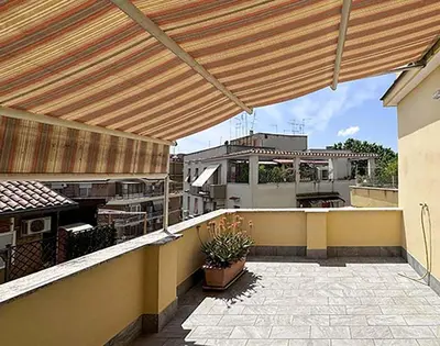 a patio with awning on top of a building at JHHIT - Panoramic Modern Penthouse in Rome