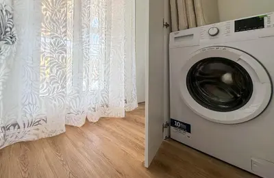 a washing machine in a room with a window at JHHIT - Panoramic Modern Penthouse in Rome