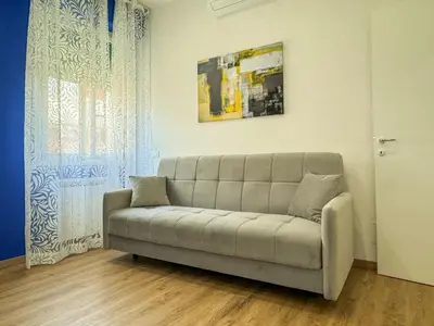 a couch sitting in a living room next to a window at JHHIT - Panoramic Modern Penthouse in Rome
