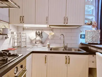a kitchen with white cabinets and a sink at Appartamento elegante con terrazzino a San Lorenzo in Rome