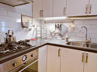 a white kitchen with a sink and a stove at Appartamento elegante con terrazzino a San Lorenzo in Rome