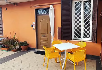 a table and chairs in front of a door at Appartamento elegante con terrazzino a San Lorenzo in Rome