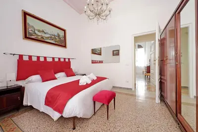 a bedroom with a red and white bed and a chandelier at 4BNB - Monteverde Chic & Comfort in Rome