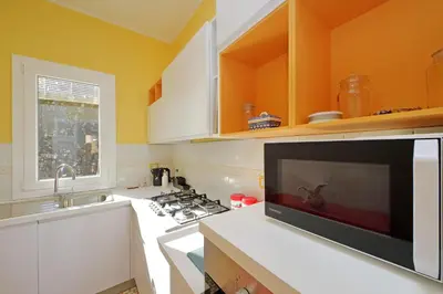 a kitchen with a stove and a sink and a microwave at 4BNB - Monteverde Chic & Comfort in Rome