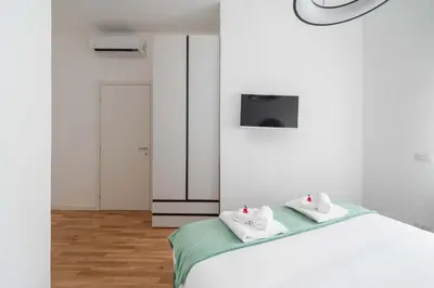 a white room with a bed with towels on it at Domus 50 in Rome