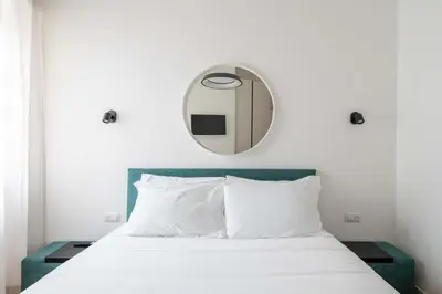 a bedroom with a bed with a mirror above it at Domus 50 in Rome