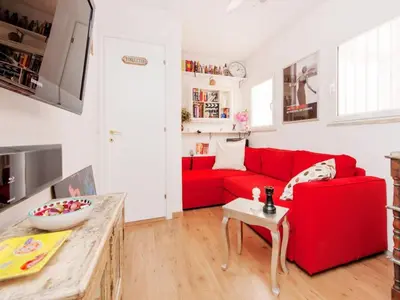 a living room with a red couch and a table at Apartment La Terrazza by Interhome in Rome