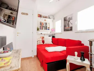 a red couch in a living room with white walls at Apartment La Terrazza by Interhome in Rome