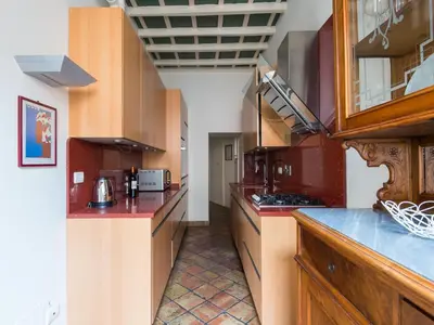 a large kitchen with red counter tops and wooden cabinets at Apartment Pantheon View by Interhome in Rome