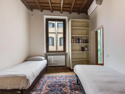 two beds in a room with a window and a rug at Apartment Pantheon View by Interhome in Rome