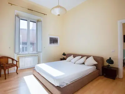 a bedroom with a white bed and a large window at Apartment Babuino by Interhome in Rome