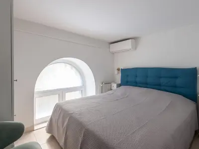 a bedroom with a blue bed and a window at Apartment Il Nido by Interhome in Rome