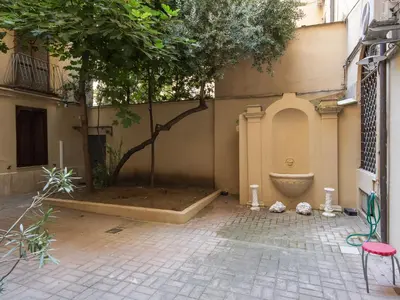 a courtyard with a tree in the corner of a building at Apartment Il Nido by Interhome in Rome