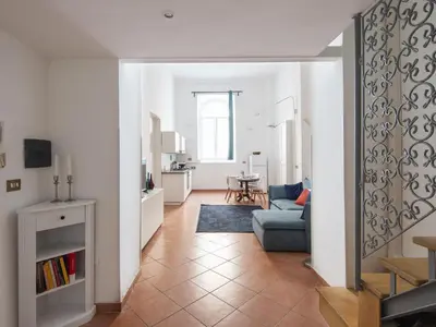 a living room with a blue couch and a kitchen at Apartment Il Nido by Interhome in Rome