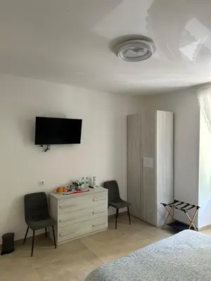 a bedroom with two chairs and a tv and a dresser at YouRoominRome in Rome