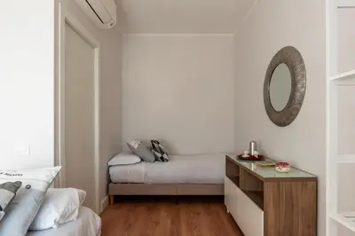 a bedroom with a bed and a mirror on the wall at YCH-Ponte Lungo apartment in Rome