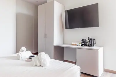 a white room with a bed with towels on it at Vatican Pertusa Luxury Suites by Quinto Piano in Rome