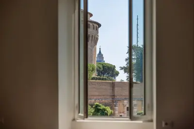 an open window with a view of a tower at Vatican Pertusa Luxury Suites by Quinto Piano in Rome