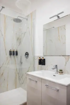a white bathroom with a sink and a shower at Vatican Pertusa Luxury Suites by Quinto Piano in Rome