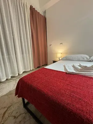 a bedroom with a bed with a red blanket on it at Residenza Piramide in Rome