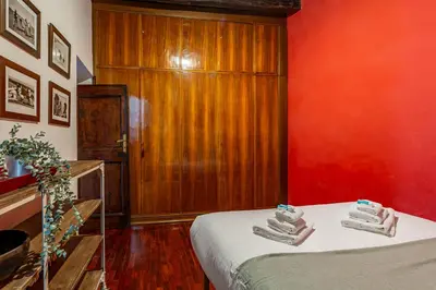 a room with a bed and a red wall at iFlat A Vintage Gem Apartment near Piazza Navona in Rome