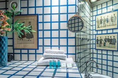 a bathroom with blue and white tiled walls and a sink at iFlat A Vintage Gem Apartment near Piazza Navona in Rome
