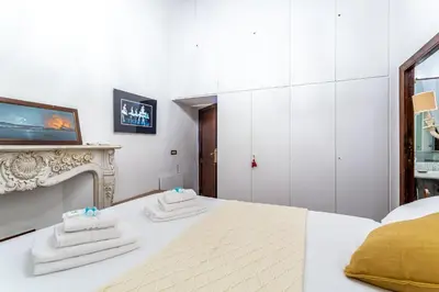 a white bedroom with a bed with towels on it at iFlat A Vintage Gem Apartment near Piazza Navona in Rome