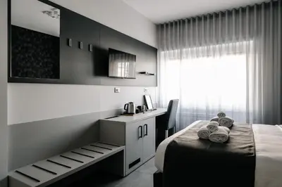 a bedroom with a bed and a desk and a window at B&B Lumas Up in Rome