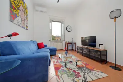 a living room with a blue couch and a tv at Vatican 47 in Rome