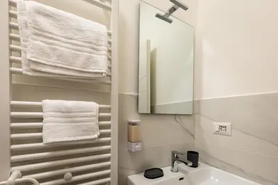 a bathroom with a sink and a mirror and towels at Il balconcino di Emma in Rome