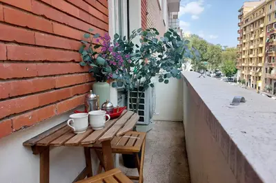 a small table on a balcony with flowers on it at Giuliana Vatican Family Home in Rome