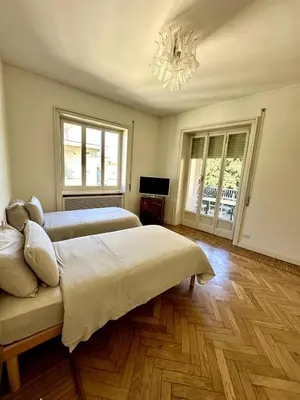 a bedroom with two beds and a chandelier at Dimora XIX in Rome